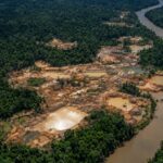 Área de garimpo ilegal na Amazônia vista de cima, próxima a um rio