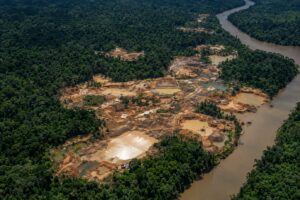 Área de garimpo ilegal na Amazônia vista de cima, próxima a um rio