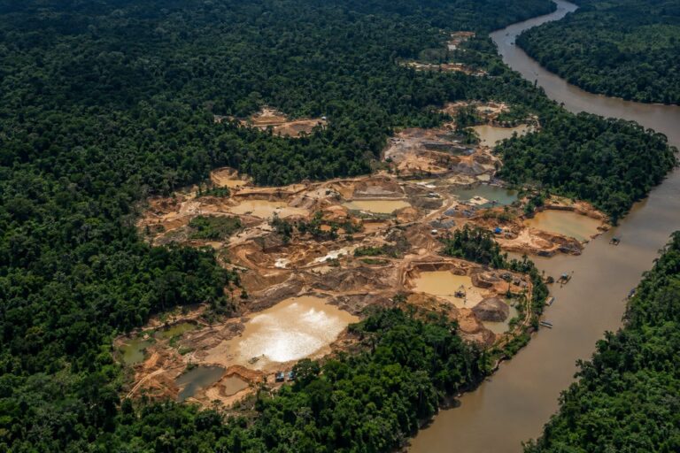Área de garimpo ilegal na Amazônia vista de cima, próxima a um rio
