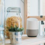 Hub de casa inteligente sobre uma estante branca, lembrando o segmento que a Apple deve explorar com o HomePad