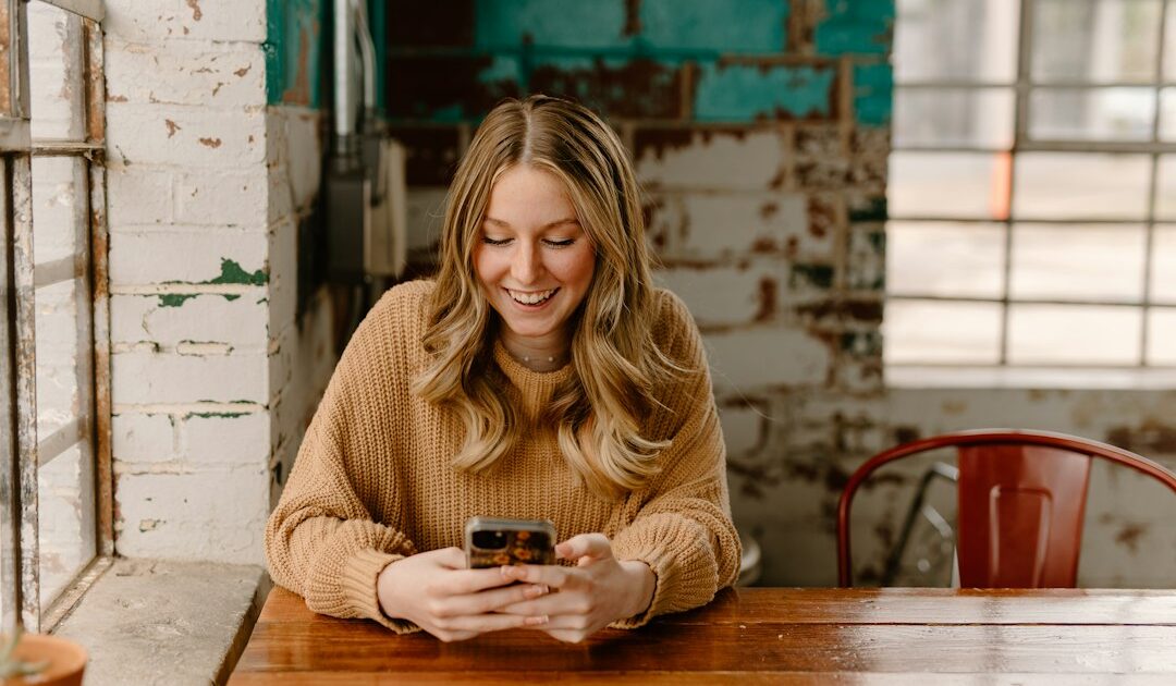 Dia Mundial da Saúde Mental: por que o Brasil recorre à IA 1 mulher sentada olhando para o celular, representando o cuidado com a saúde mental no Dia Mundial da Saúde Mental