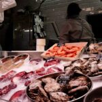 Peixes frescos expostos no gelo em um mercado, representando a venda de pescado em peixarias