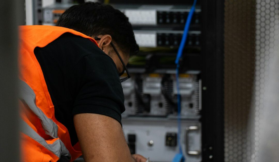 Dia do profissional de informática aquece o mercado de TI 1 Técnico trabalhando em equipamento de servidor, simbolizando o dia do profissional de informática