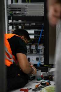 Técnico trabalhando em equipamento de servidor, simbolizando o dia do profissional de informática